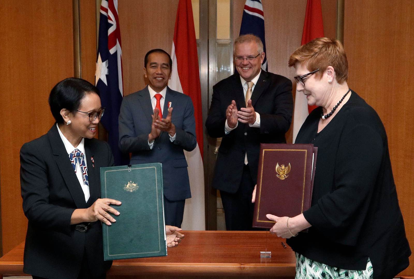 Indonesia’s President Joko Widodo and Australia’s Prime Minister Scott Morrison watch as foreign ministers Retno Marsudi and Marise Payne sign agreements in Canberra on 10 February (Photo: Rick Rycroft/AFP/Getty Images)