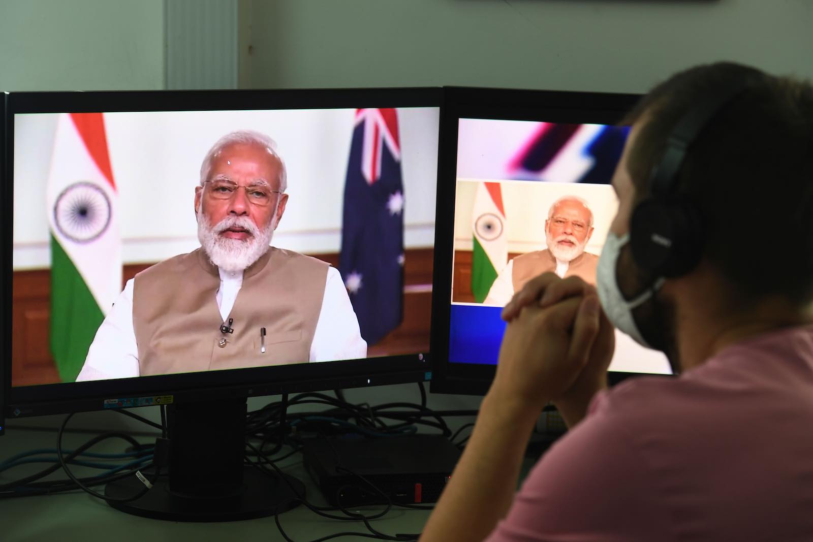 A man watches Indian Prime Minister Narendra Modi speak during a bilateral virtual summit with Australian Prime Minister Scott Morrison (Prakash Singh/AFP via Getty Images)