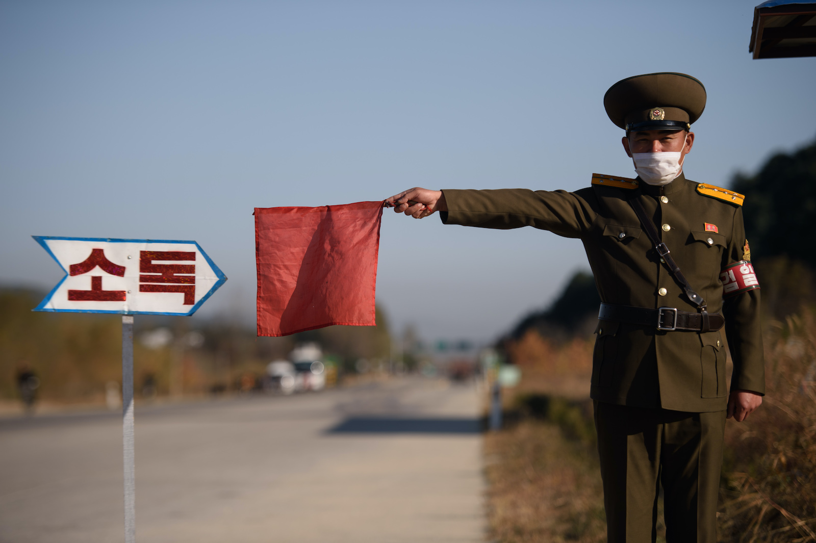 A security officer stopping a taxi for disinfection on the road to Wonsan, Kangwon province, North Korea, 29 October 2020, (Kim Won Jin/AFP via Getty Images)