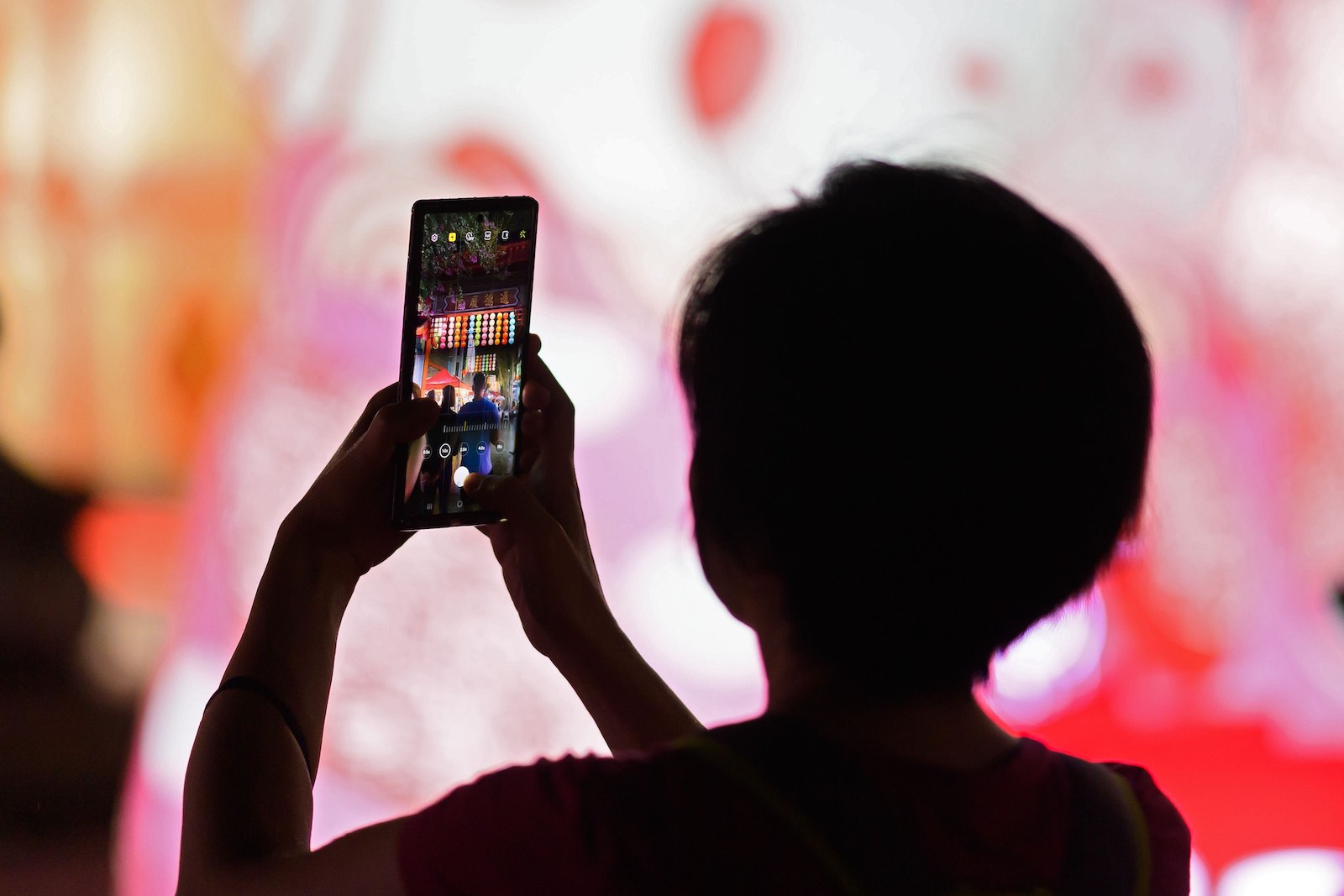 A woman takes a photo during Lunar New Year celebrations in Sydney, 12 February 2021 (Wendell Teodoro/AFP via Getty Images)