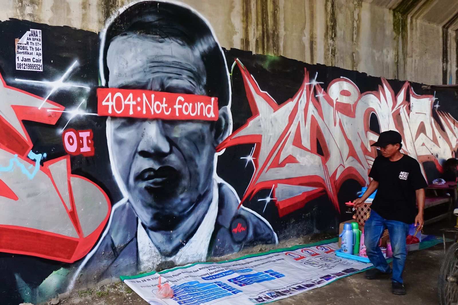 A mural depicting Indonesian President Joko Widodo with a “404: not found” network error message covering his eyes in Tangerang, Jakarta, before being painted over (Fajrin Raharjo/AFP via Getty Images)