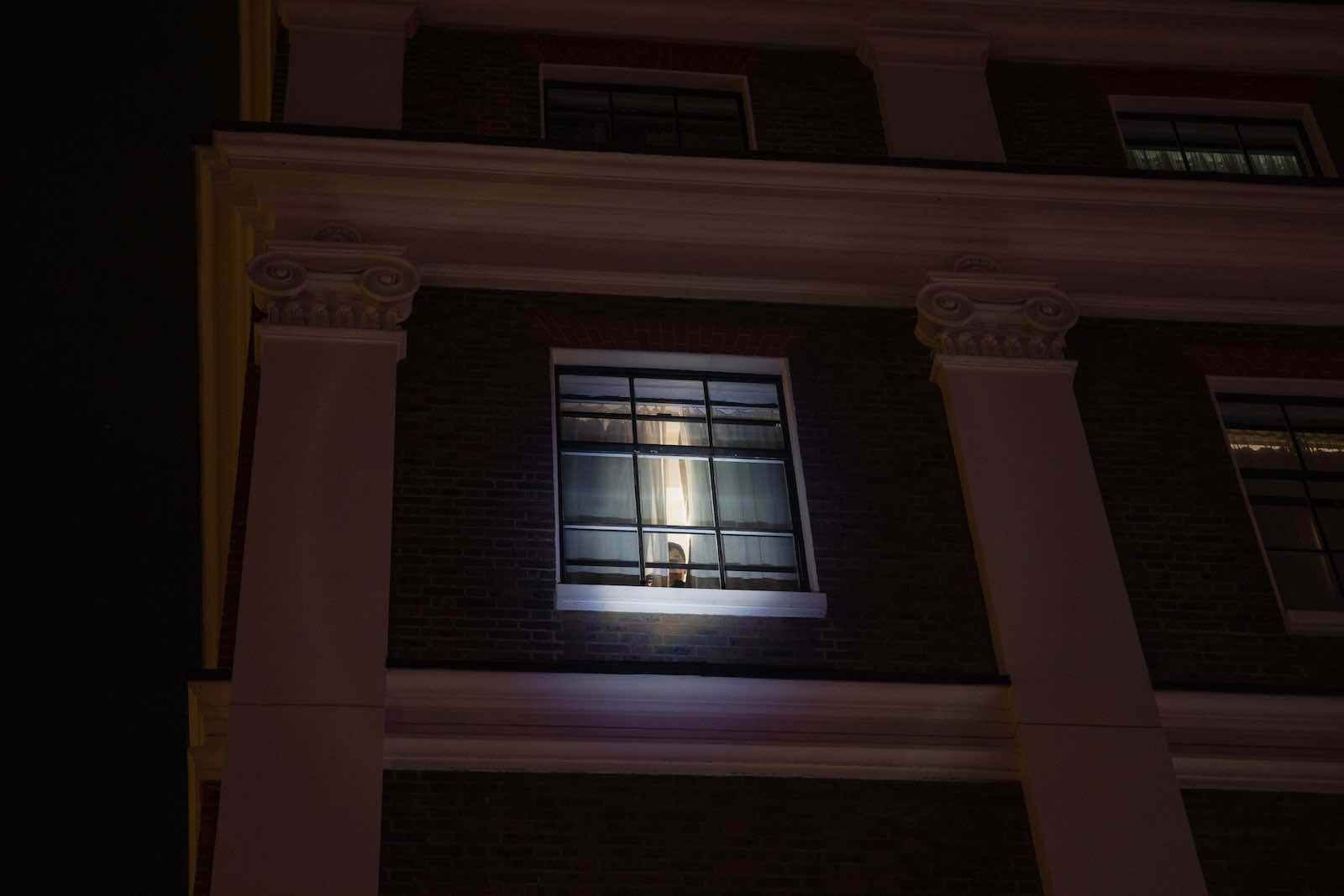 A member of the Chinese embassy in London staff peeks at protests in October demonstrating against the treatment of ethnic minority communities in China (Hesther Ng via Getty Images)