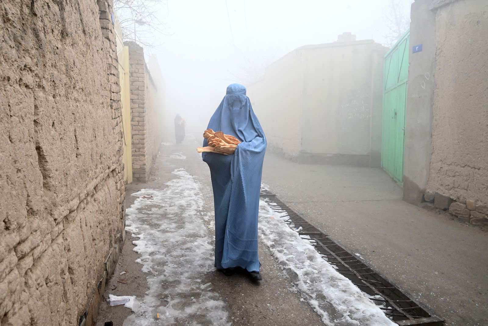 A burqa-clad woman after receiving handouts of bread in Kabul on 18 January (Wakil Kohsar/AFP via Getty Images)
