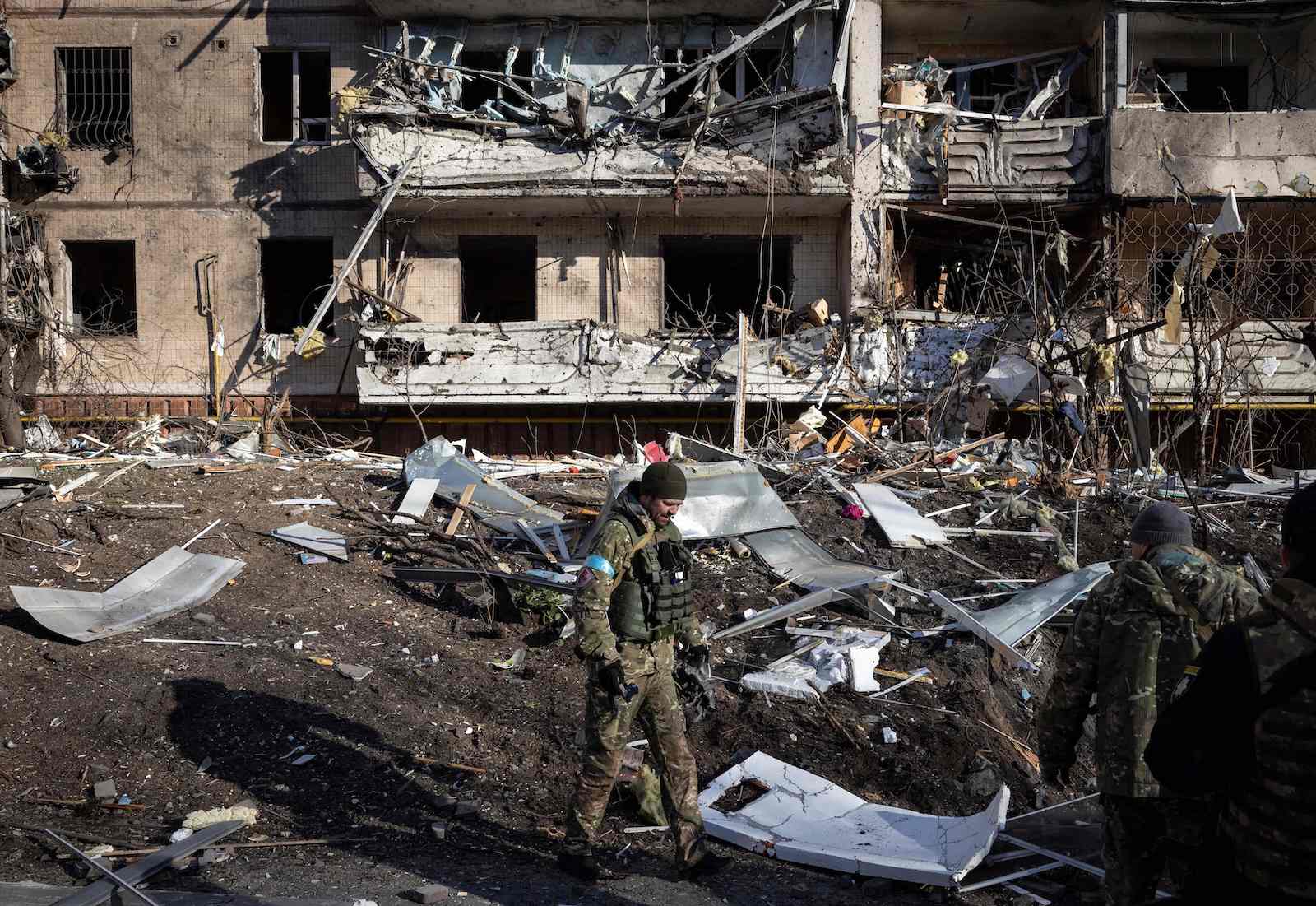 A Ukraine soldier inspects the rubble of a destroyed apartment building in Kyiv on 15 March (Fadel Senna/AFP via Getty Images)
