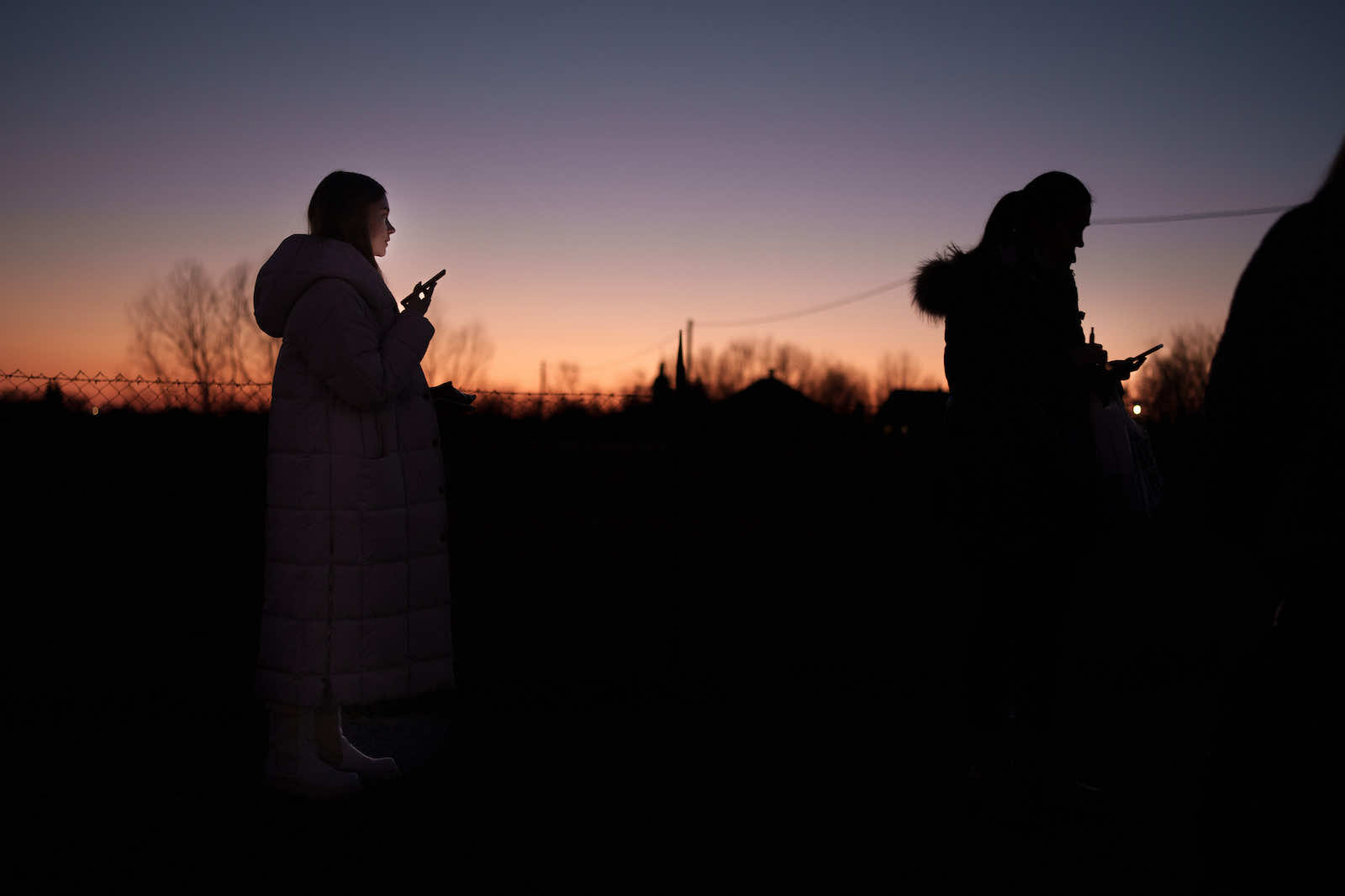 Refugees fleeing Ukraine use their smart phones to make calls and send messages at the border crossing on 13 March, Velke Slemence, Slovakia (Christopher Furlong/Getty Images)
