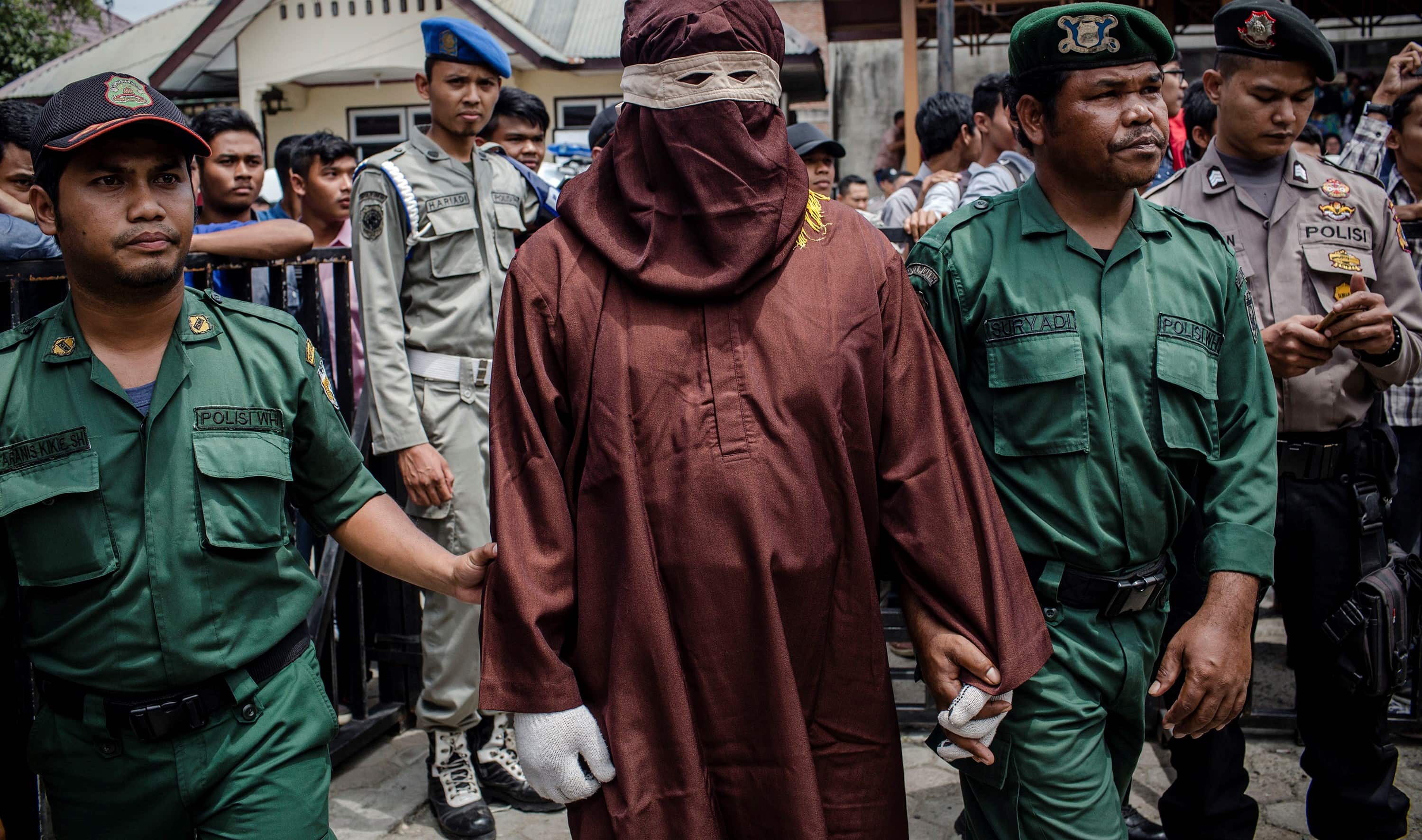 A judicial executor known as an 'algojo' stands by before a public caning in Aceh, Indonesia, March 2017 (Photo: Ulet Ifansasti/Getty Images)