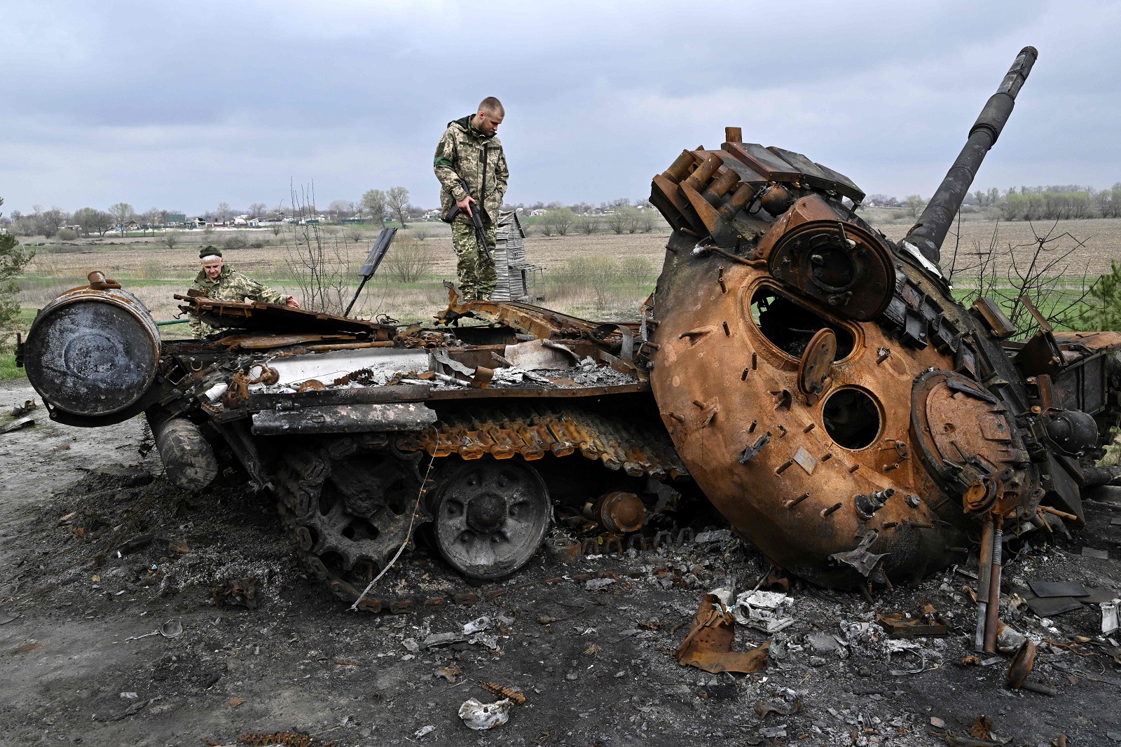 Ukrainian servicemen on a destroyed Russian tank in the village of Rusaniv, Kyiv Oblast, 16 April 2022 (Genya Savilov/AFP via Getty Images)