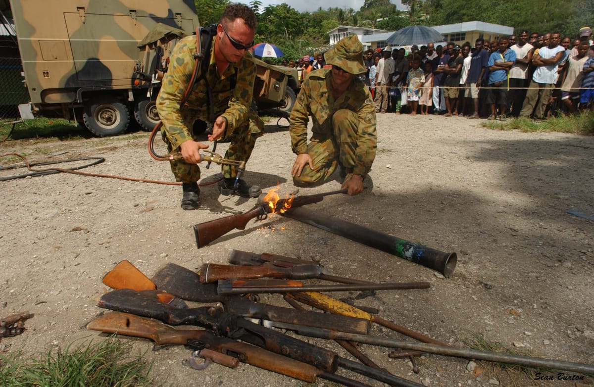 Members of RAMSI destroy surrendered weapons in the west of Honiara, Solomon Islands, 2003 (Sean Burton, Defence Department)