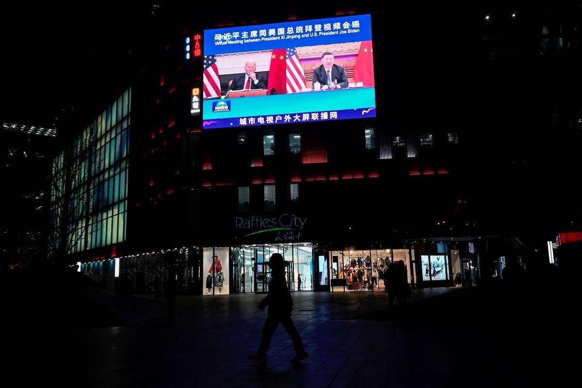 An outdoor screen shows a news program about a virtual meeting between Chinese President Xi Jinping and US President Joe Biden in Beijing on November 16, 2021. (Photo by Jade GAO / AFP) (Photo by JADE GAO/AFP via Getty Images)