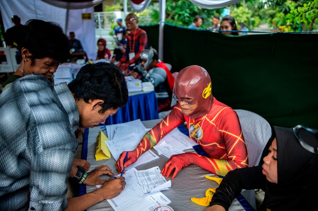 Indonesian election workers dressed in superhero costumes in 2019 to register voters at a polling station in Surabaya (Juni Kriswanto/AFP via Getty Images)