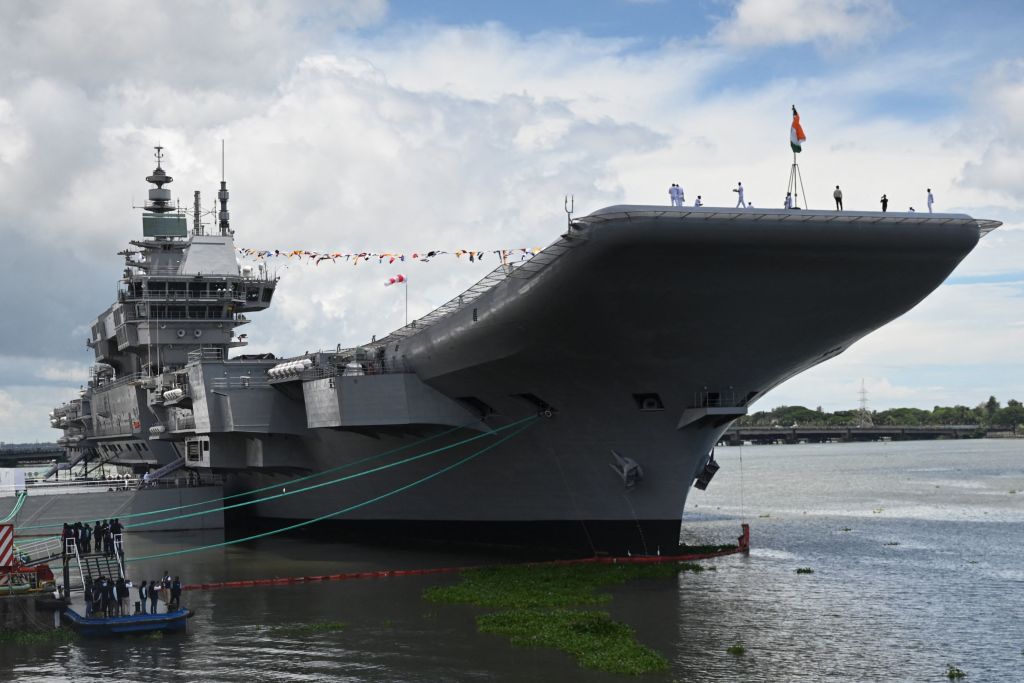 Indian Navy officers and attendees stand on deck of the Indian indigenous aircraft carrier INS Vikrant during its commissioning at Cochin Shipyard in Kochi in September 2022 (Arun Sankar/AFP via Getty Images)
