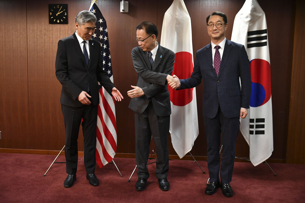 Japan's Ministry of Foreign Affairs Director General for Asian and Oceanian Affairs Funakoshi Takehiro (C), United States Special Representative for North Korea Policy Sung Kim (L), and South Korea's Special Representative for Korean Peninsula Peace and Security Affairs Kim Gunn (R), prepare to pose for photographs before their meeting at the Foreign Ministry in Tokyo on 7 September (Kazuhiro Nogi/Anadolu Agency via Getty Images)
