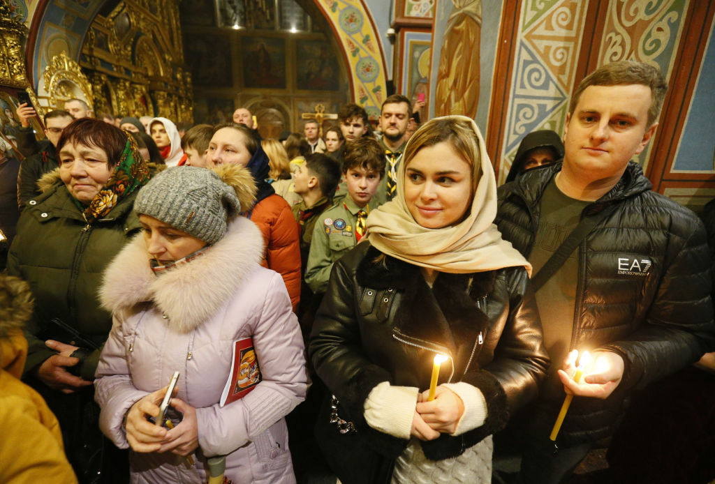 A congregation wait for the Bethlehem flame of peace during a ceremony at the St Michael's Golden-Domed Cathedral in Kyiv, Ukraine on 11 December (STR via Getty Images)