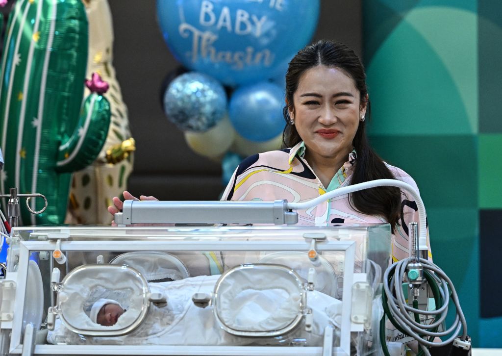 Pheu Thai Party candidate Paetongtarn Shinawatra, youngest daughter of former prime minister Thaksin Shinawatra, with her newborn son Thasin during a media event at the Praram 9 hospital in Bangkok on 3 May (Manan Vatsyayana/AFP via Getty Images)