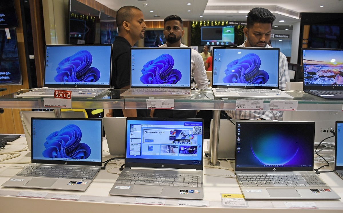 MUMBAI, MAHARASHTRA, INDIA - 2023/08/08: A customer (R) checks laptops kept on display at Vijay Sales electronic store. Sale of laptops have surged at electronic stores and e-commerce website due to fears of an increase in the price and shortage in availability of products after the government announced licence requirements for the import of laptops, tablets, personal computers (PC) and servers from 1st November 2023. Shipments will be cleared without licence requirement until 31st October 2023. (Photo by Ashish Vaishnav/SOPA Images/LightRocket via Getty Images)
