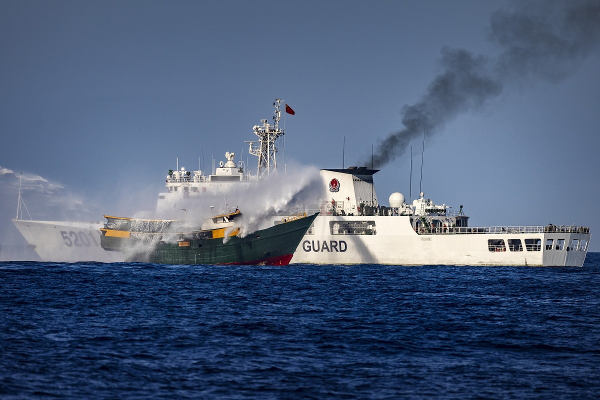 SOUTH CHINA SEA - MARCH 05: A Chinese Coast Guard ship fires a water cannon at Unaizah May 4, a Philippine Navy chartered vessel, conducting a routine resupply mission to troops stationed at Second Thomas Shoal, on March 05, 2024 in the South China Sea. Philippine and Chinese vessels collided in the high seas, leaving four Filipinos with minor injuries after a supply vessel's windshield was shattered by water cannons, the Philippines said. The incidents happened as the Philippines was conducting a routine resupply mission to troops stationed aboard BRP Sierra Madre, a grounded Navy ship that serves as the country's outpost in Second Thomas Shoal (locally called Ayungin Shoal). (Photo by Ezra Acayan/Getty Images)