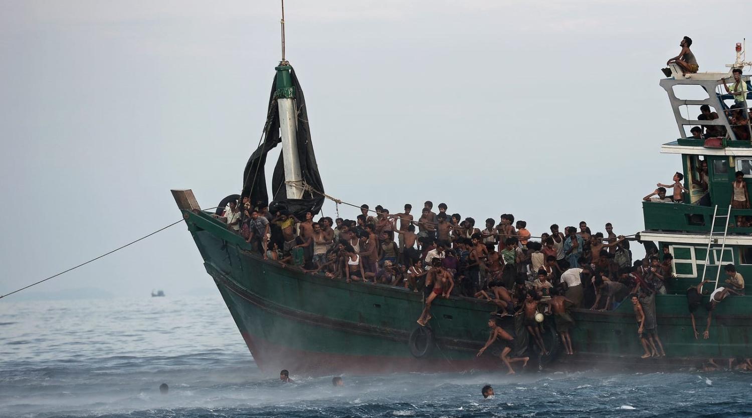 Rohingya migrants jump to collect food supplies dropped by a Thai army helicopter from a boat drifting off the southern island of Koh Lipe in the Andaman Sea, May 2015 (Christophe Archambault/AFP via Getty Images)