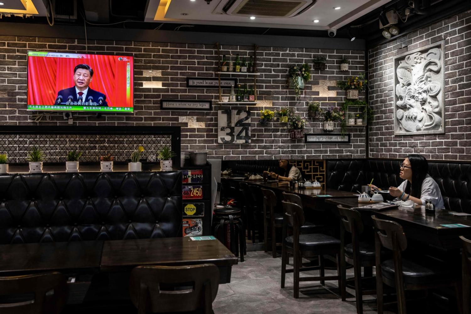 China’s President Xi Jinping is seen on a TV screen in a restaurant in Hong Kong on 16 October as he delivers the opening speech of the ruling Communist Party’s 20th party congress in Beijing (Isaac Lawrence/AFP via Getty Images)