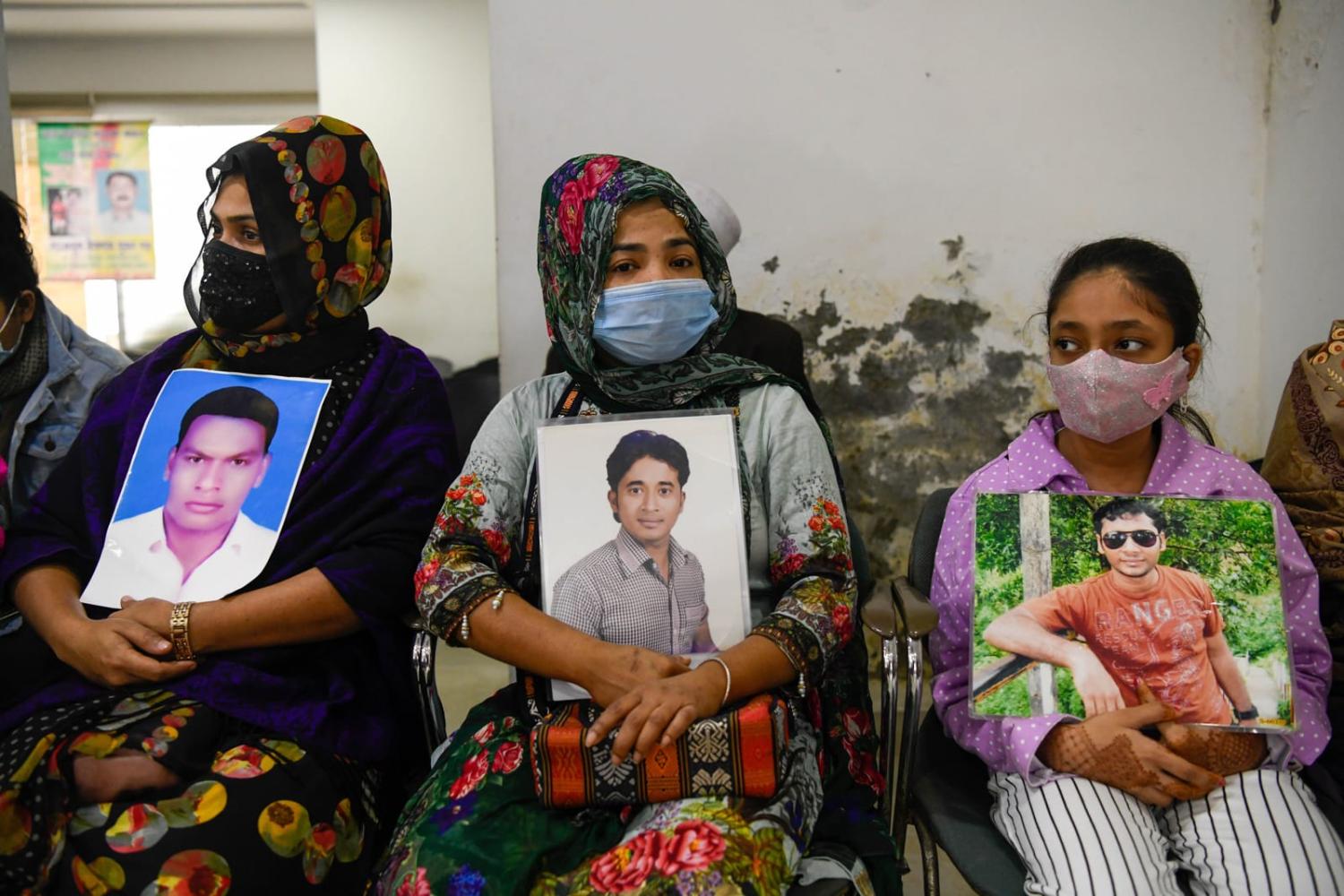 Relatives in Dhaka hold pictures of missing persons in May last year, saying they have disappeared often after visiting various government offices including police and Rapid Action Battalion (Piyas Biswas via Getty Images)