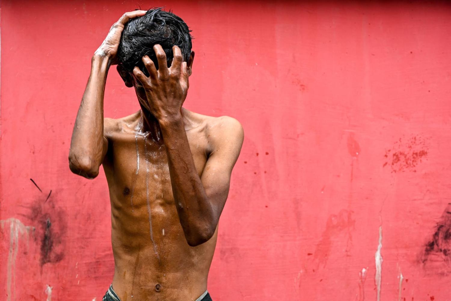 A Rohingya refugee bathes at a temporary shelter after arriving by boat in Laweueng, Aceh province, Indonesia, on 27 December (Chaideer Mahyuddin/AFP via Getty Images)