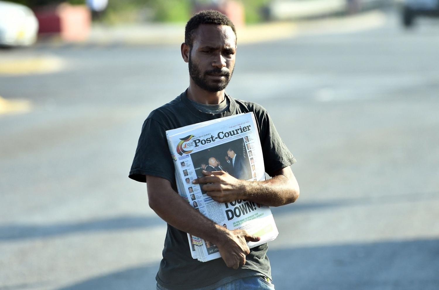 A man sells morning newspapers on a street in Port Moresby, Papua New Guinea, 2018 (Saeed Khan/AFP via Getty Images)