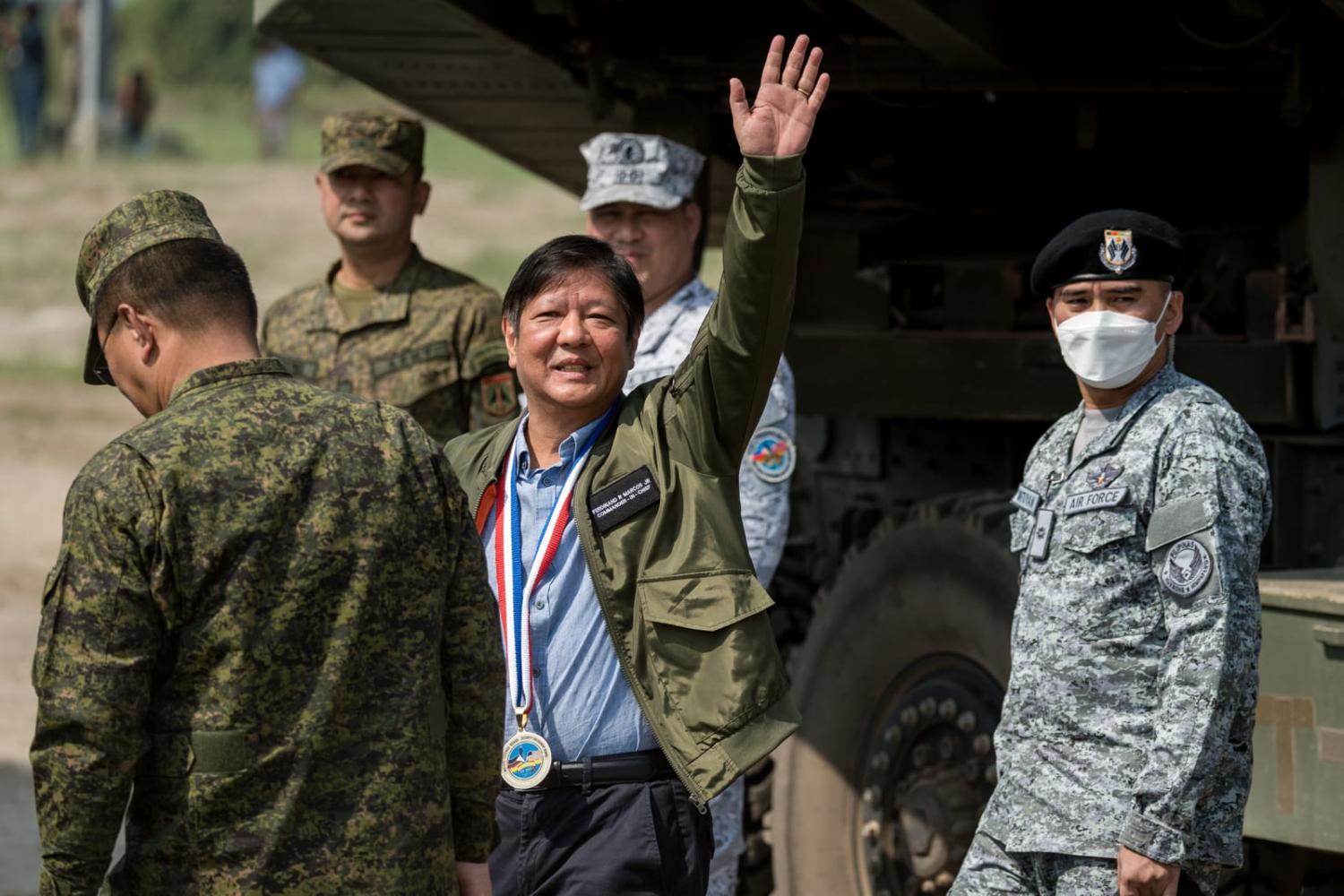 Philippines President Ferdinand Marcos Jr waves ahead of a live fire drill as part of the US-Philippines Balikatan joint military exercise at Zambales on 26 April (Iya Forbes/Bloomberg via Getty Images)