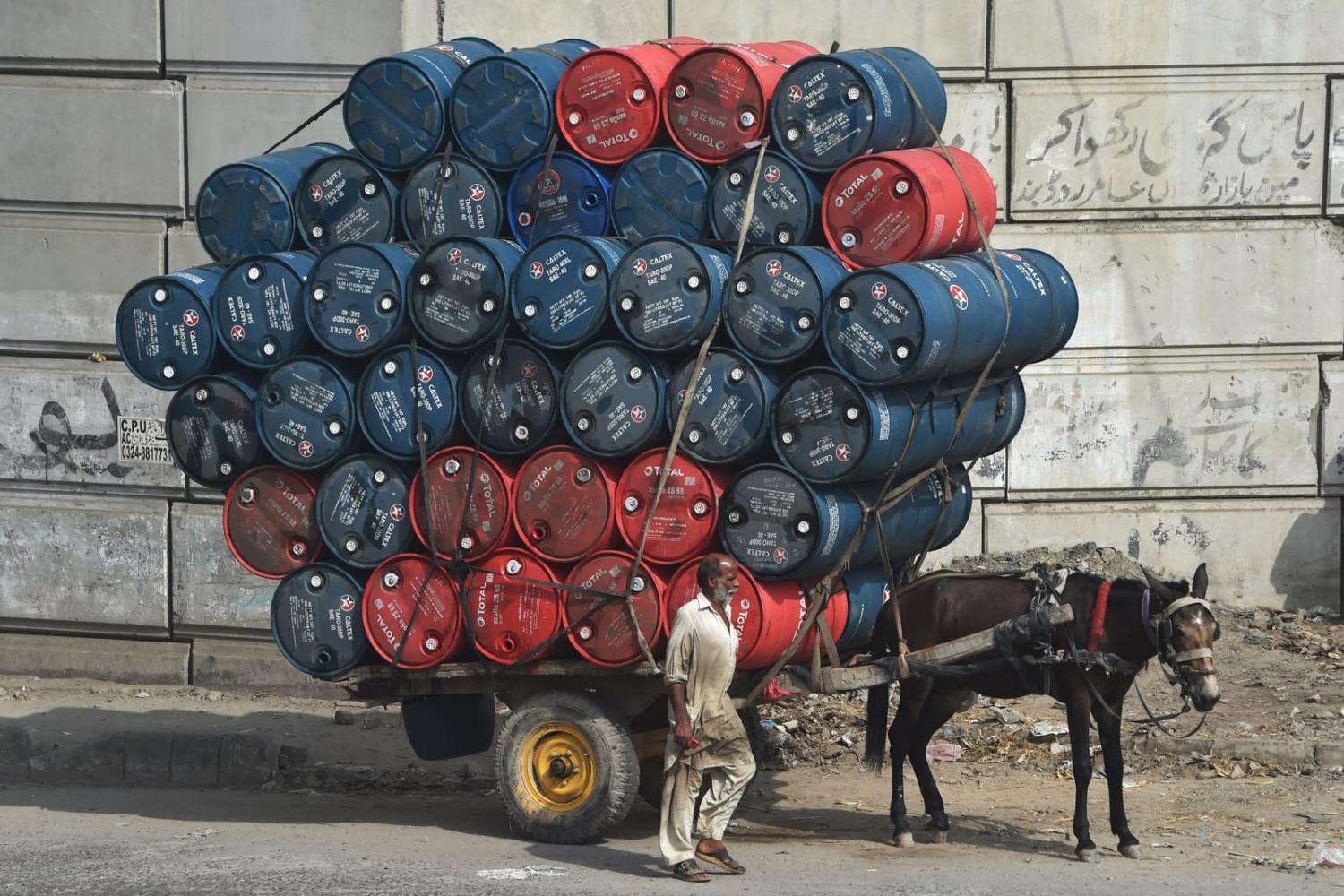 Transporting oil drums on a street in Lahore (Arif ALI/AFP via Getty Images)