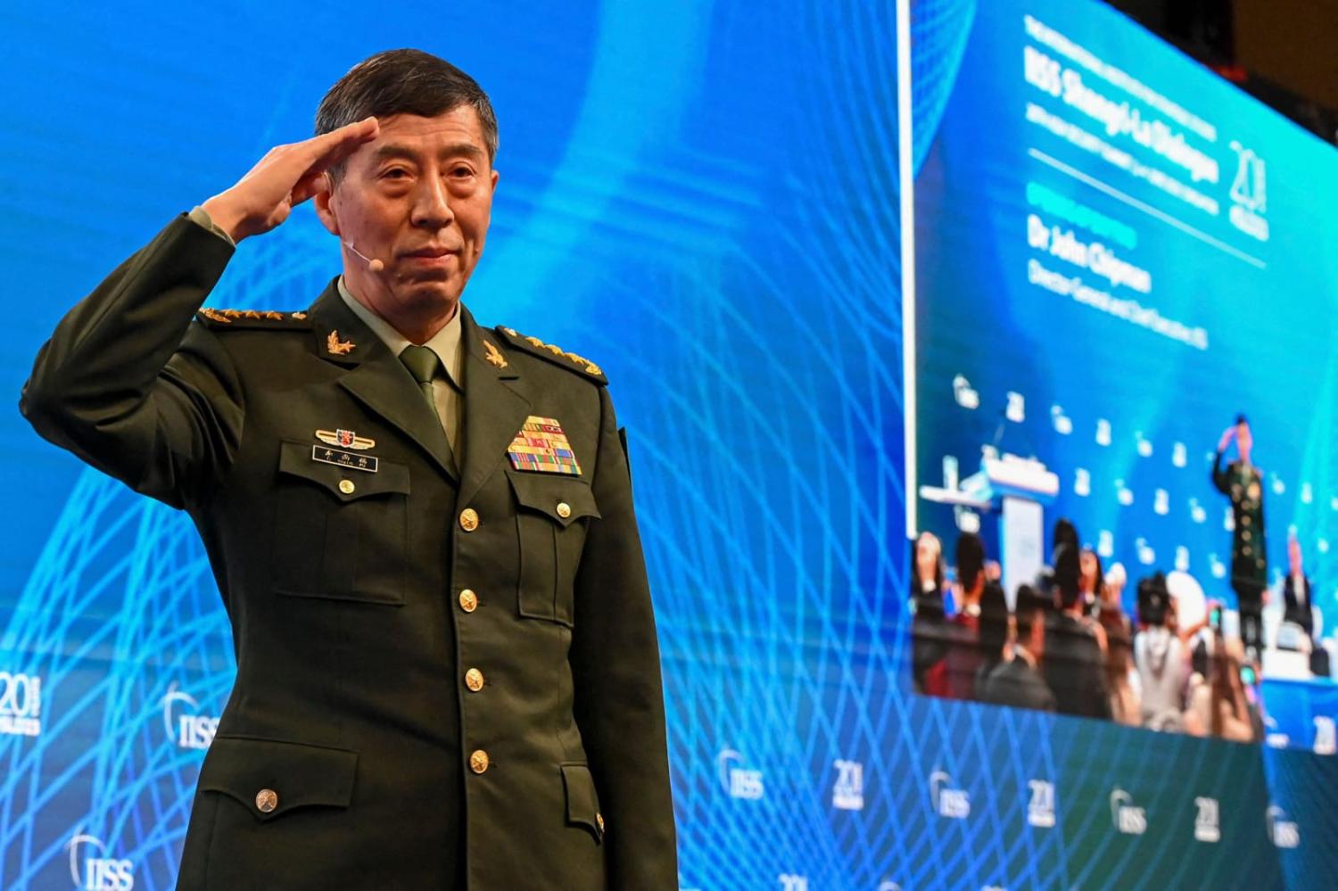 China’s Minister of National Defence Li Shangfu salutes the audience before delivering a speech during the 20th Shangri-La Dialogue summit in Singapore on 4 June (Roslan Rahman/AFP via Getty Images)