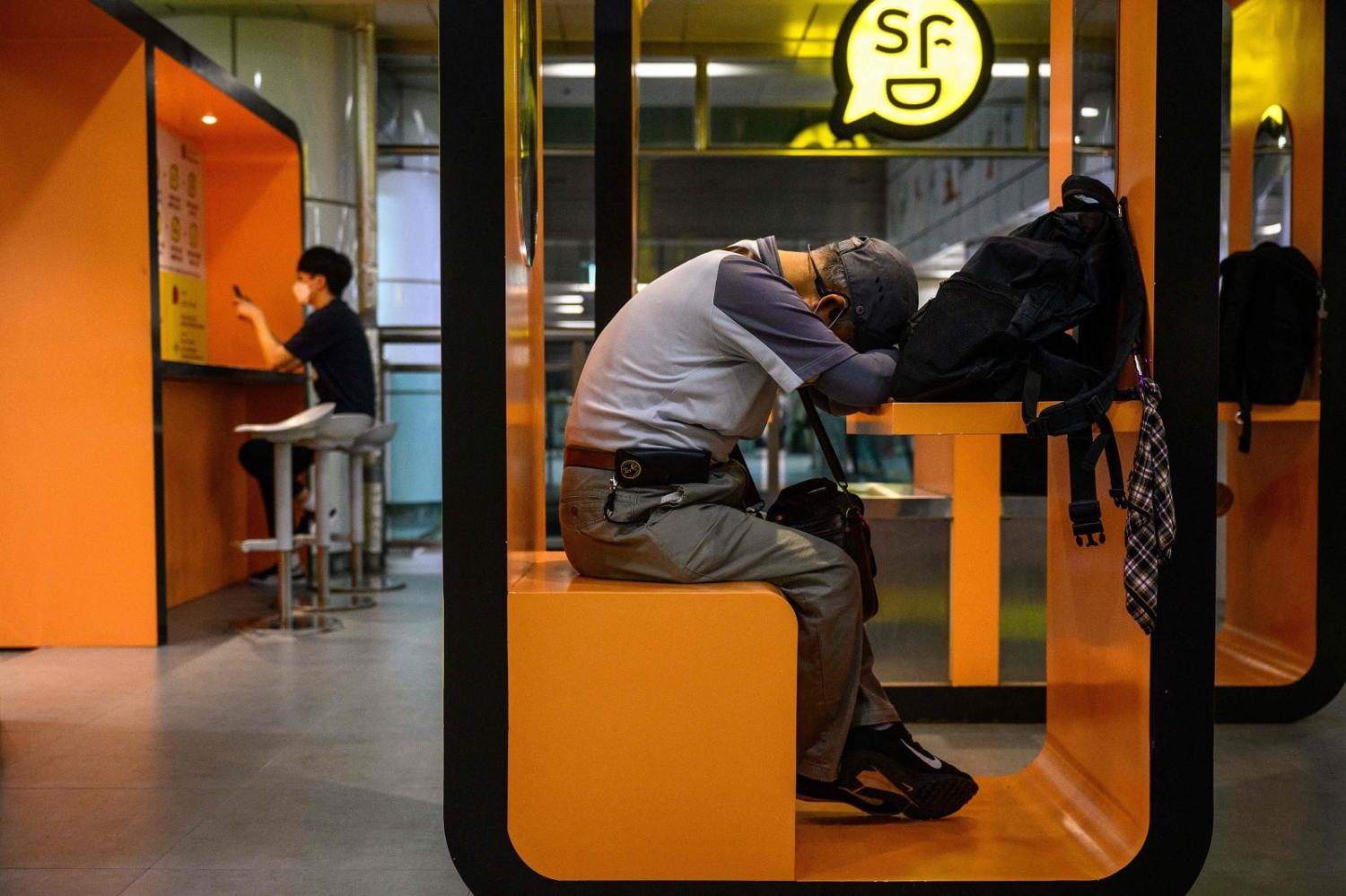 It is expected to take generations for many South Koreans to reach mean income status. A man naps in a cubicle at an underground train station in Seoul (Anthony Wallace/AFP via Getty Images)