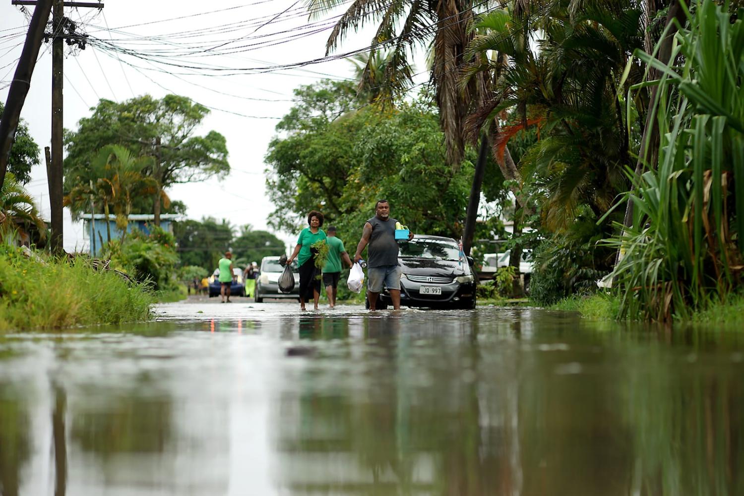 Residents wade through flooded streets in Fiji's capital city of Suva in December 2020 ahead of super Cyclone Yasa (Leon Lord/AFP via Getty Images)