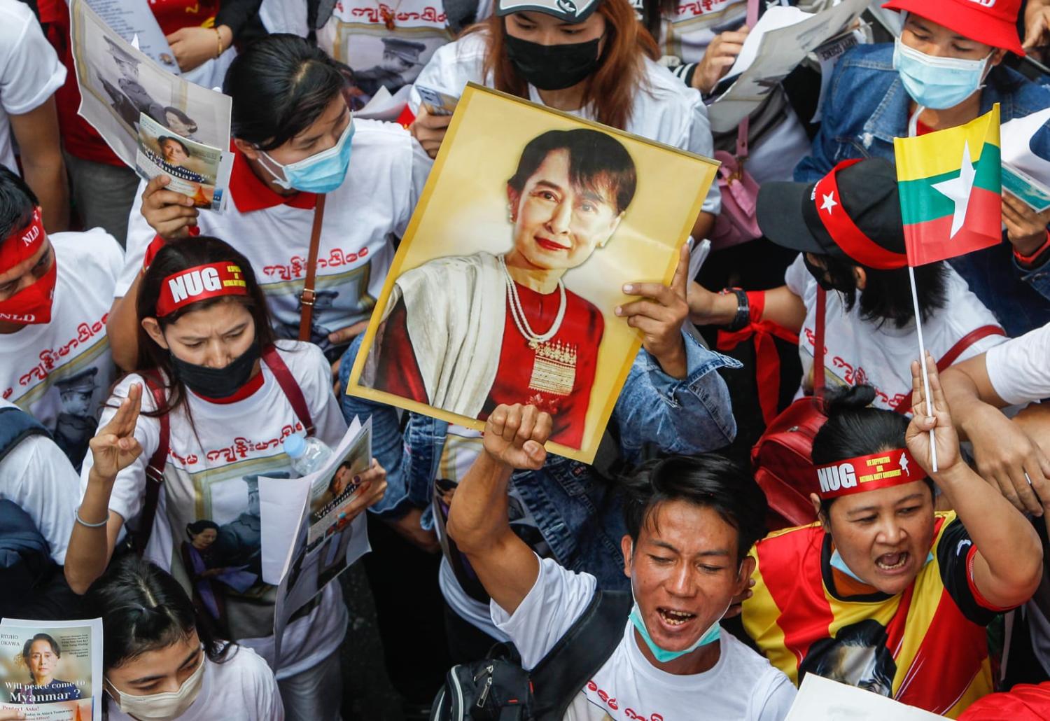 Demonstrators hold a portrait of Aung San Suu Kyi and raise a three-finger salute during a rally to mark the second anniversary of the February 2021 coup in Myanmar outside the Myanmar embassy in Bangkok (Chaiwat Subprasom via Getty Images)