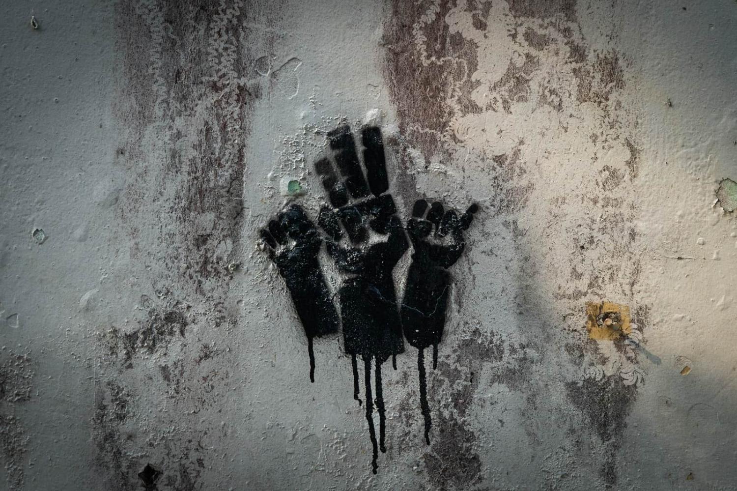 Graffiti in Yangon depicts the three-finger salute, a symbol adopted by pro-democracy resistance movements in Mynmar, 3 April 2023 (Matt Hunt/Anadolu Agency via Getty Images)