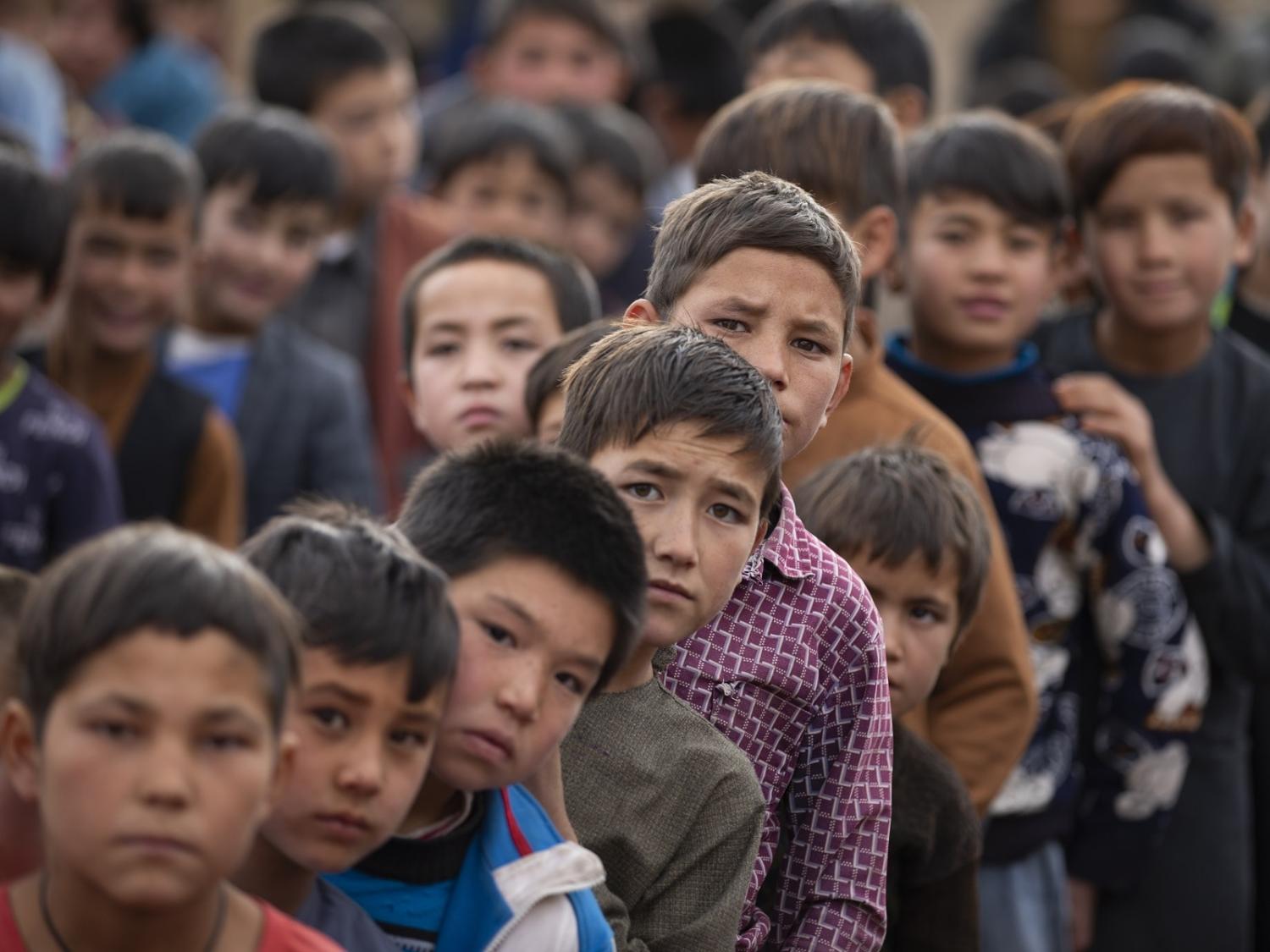 Children wait in line for aid in Kabul, Afghanistan on 3 January 2023 (Muhammed Abdullah Kurtar/Anadolu Agency via Getty Images)