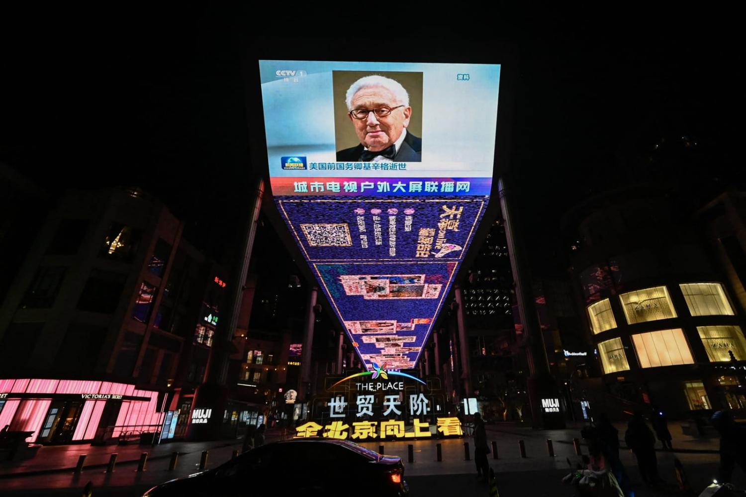 An outdoor screen in Beijing shows a news program following the death of former US Secretary of State Henry Kissinger on 30 November (Pedro Pardo/AFP via Getty Images)