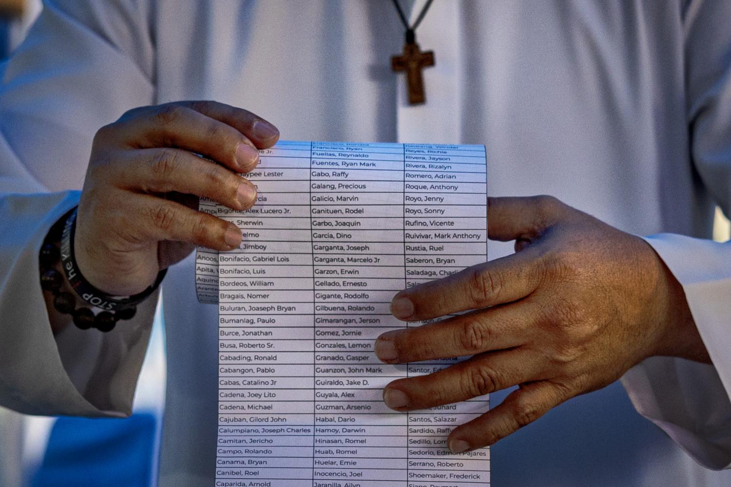 A priest this month places a list of names of drug war victims inside an urn at La Loma Catholic Cemetery, Manila, during the ground-breaking for the first ever memorial for victims of the drug war (Ezra Acayan/Getty Images)