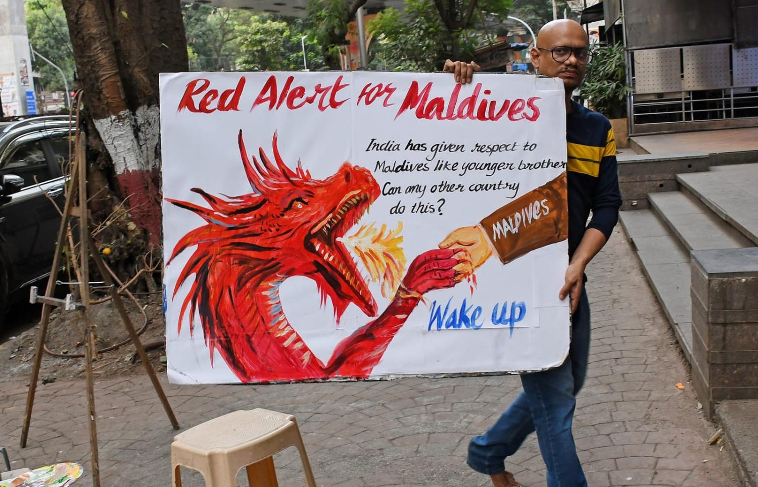 An art teacher in Mumbai shows a poster painted to condemn Maldives ministers' statements this month about Indian Prime Minister Narendra Modi (Ashish Vaishnav via Getty Images)
