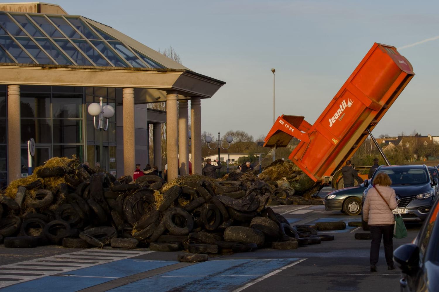 Farmers unload manure to block a supermarket entrance in Le Mans, northwestern France, to protest costs and regulations (Guillaume Souvant/AFP via Getty Images)