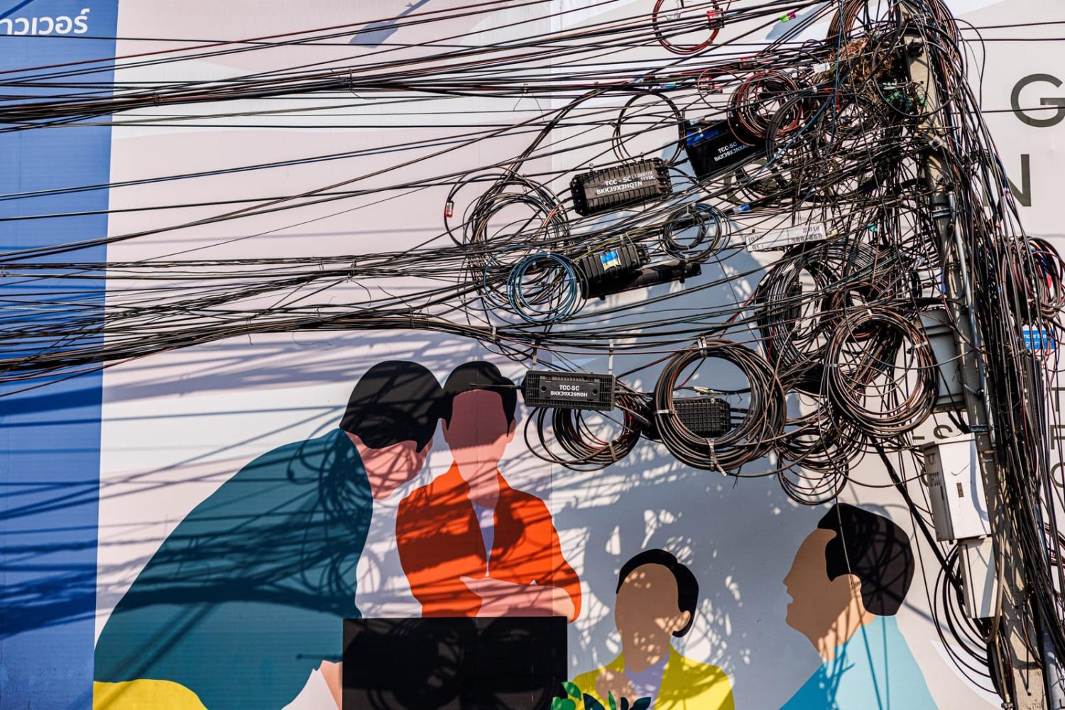 A nest of power lines on a busy street corner in Bangkok, Thailand, 1 February, 2024 (Lauren DeCicca/Getty Images)