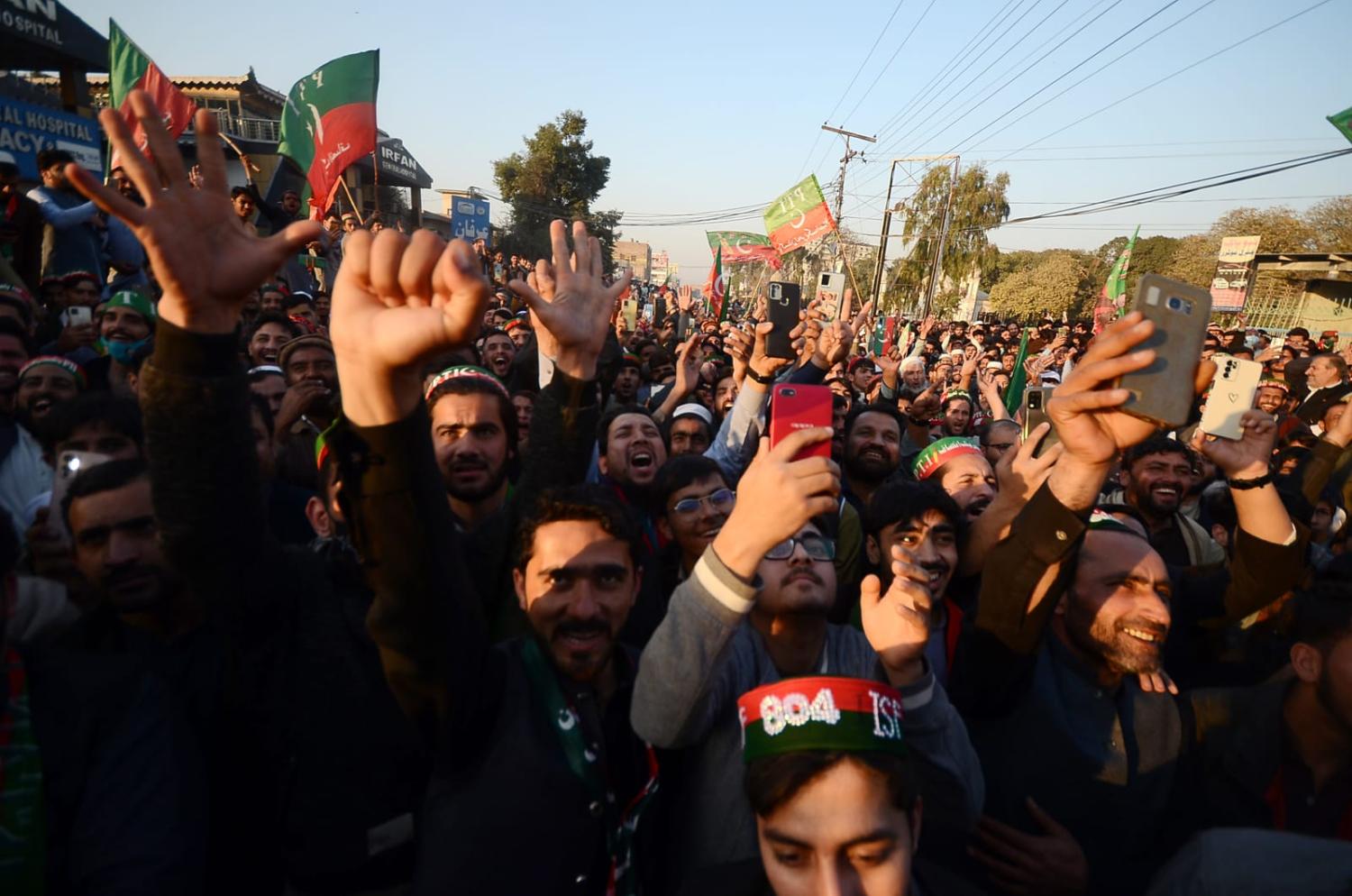Supporters of the convicted former Pakistani Prime Minister Khan's Pakistan Tehrik-e-Insaf (PTI) political party hold their phones aloft at a rally in Peshawar on 10 February (Hussain Ali/Anadolu via Getty Images)
