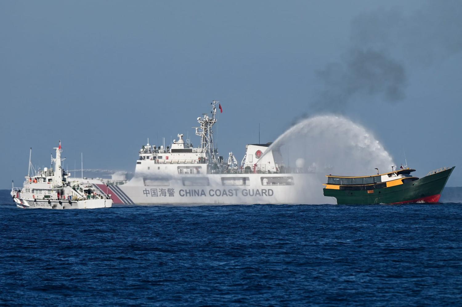 This photo taken on March 5, 2024 shows China Coast Guard vessels deploying water cannons at the Philippine military chartered Unaizah May 4 (R) during its supply mission to Second Thomas Shoal (Jam Sta Rosa/AFP via Getty Images)