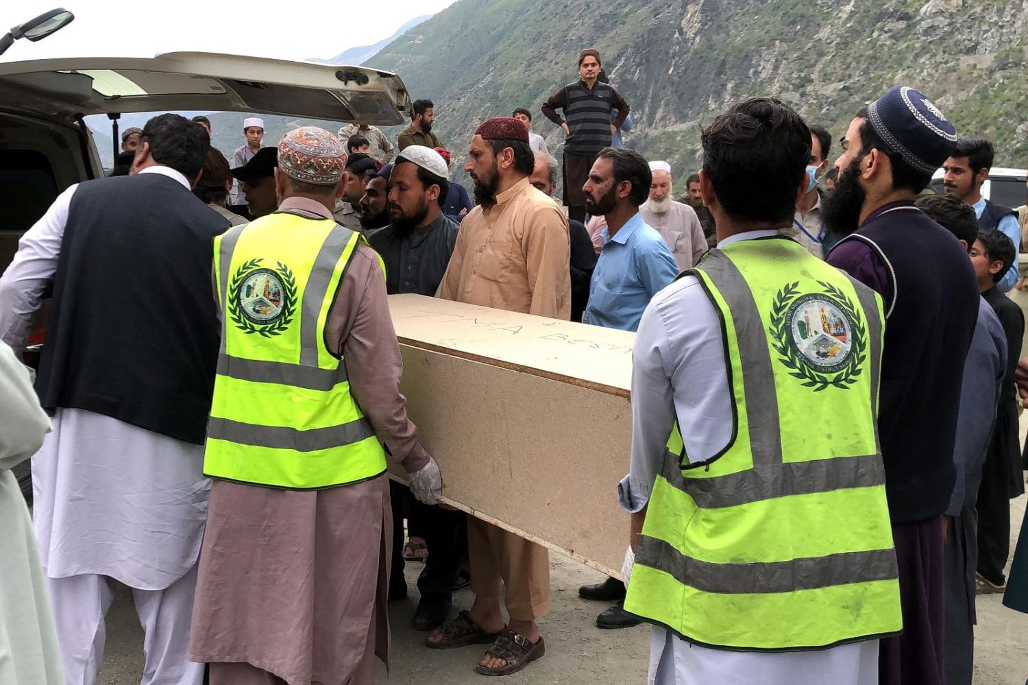 Volunteers transport the coffins of Chinese nationals following a suicide attack in Besham city in Khyber Pakhtunkhwa province on 26 March 2024 (Omar Bacha/AFP via Getty Images)