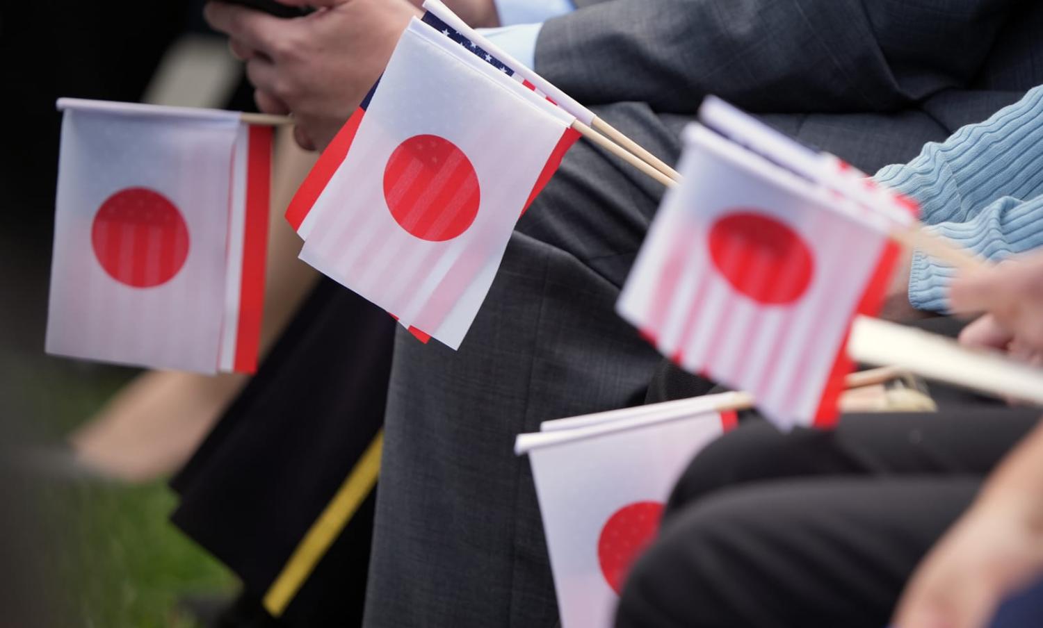 Guests hold Japanese and US flags ahead of the arrival of Japan’s Prime Minister Fumio Kishida and wife Yuko Kishida at White House last month for a state dinner (Andrew Harnik/Getty Images)