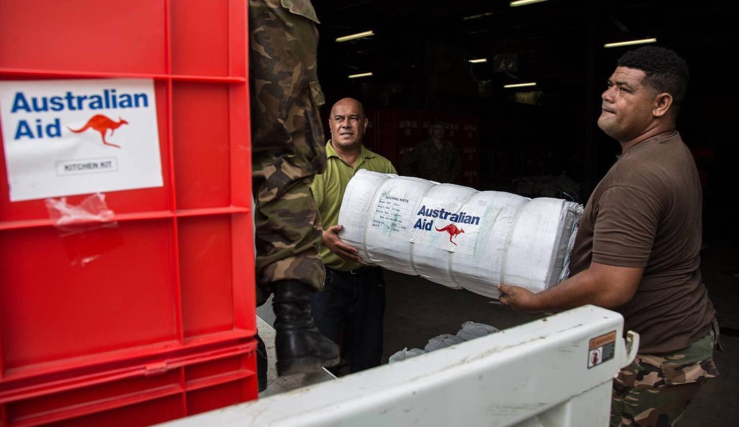 A volunteer helps a Tonga Defense Service soldier unload Australian aid supplies after Cyclone Gita, May 2018 (Photo: AHC Nakualofa/Flickr)
