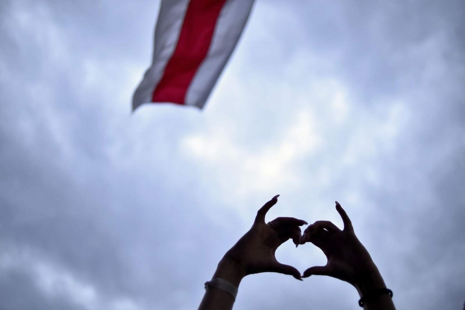 A demonstrator gestures a love heart during a rally to protest against disputed presidential elections in Minsk, 25 August 2020 (Sergei Gapon/AFP via Getty Images)