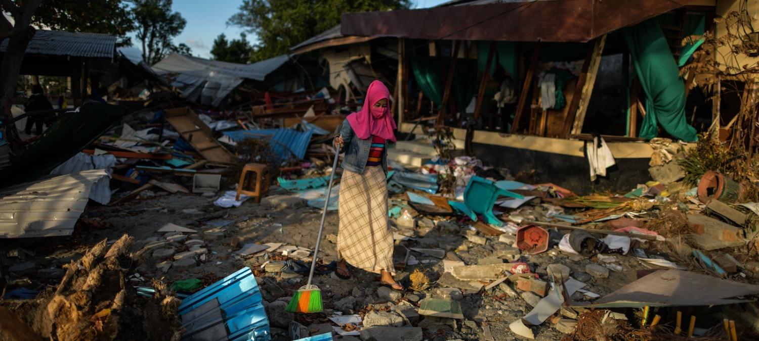 A woman clears debris from her home after the tsunami in Sulawesi (Photo: Mohd Rasfan via Getty)