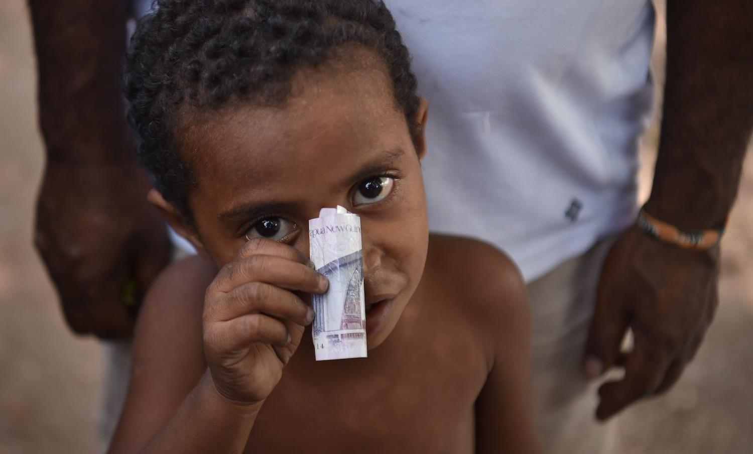 A boy and his kina, in Port Moresby (Photo: Peter Parks/AFP/Getty Images)