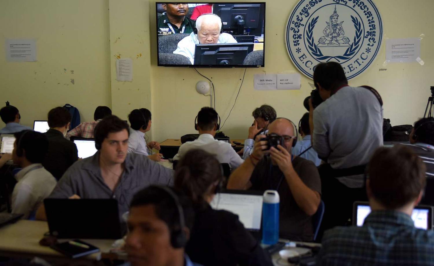 Journalists watch the verdict for former Khmer Rouge leader Khieu Samphan shown on a live video broadcast on 16 November (Photo: Tang Chhin Sothy via Getty)