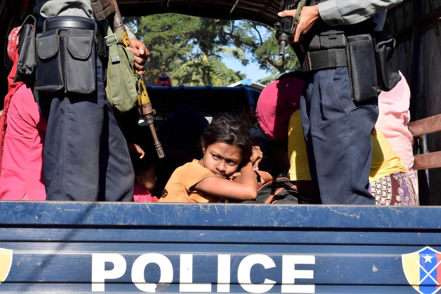 Myanmar police escort Rohingya back to their camp in Sittwe, Rakhine state, after being detained at sea, November 2018 (Photo: AFP/Getty Images)