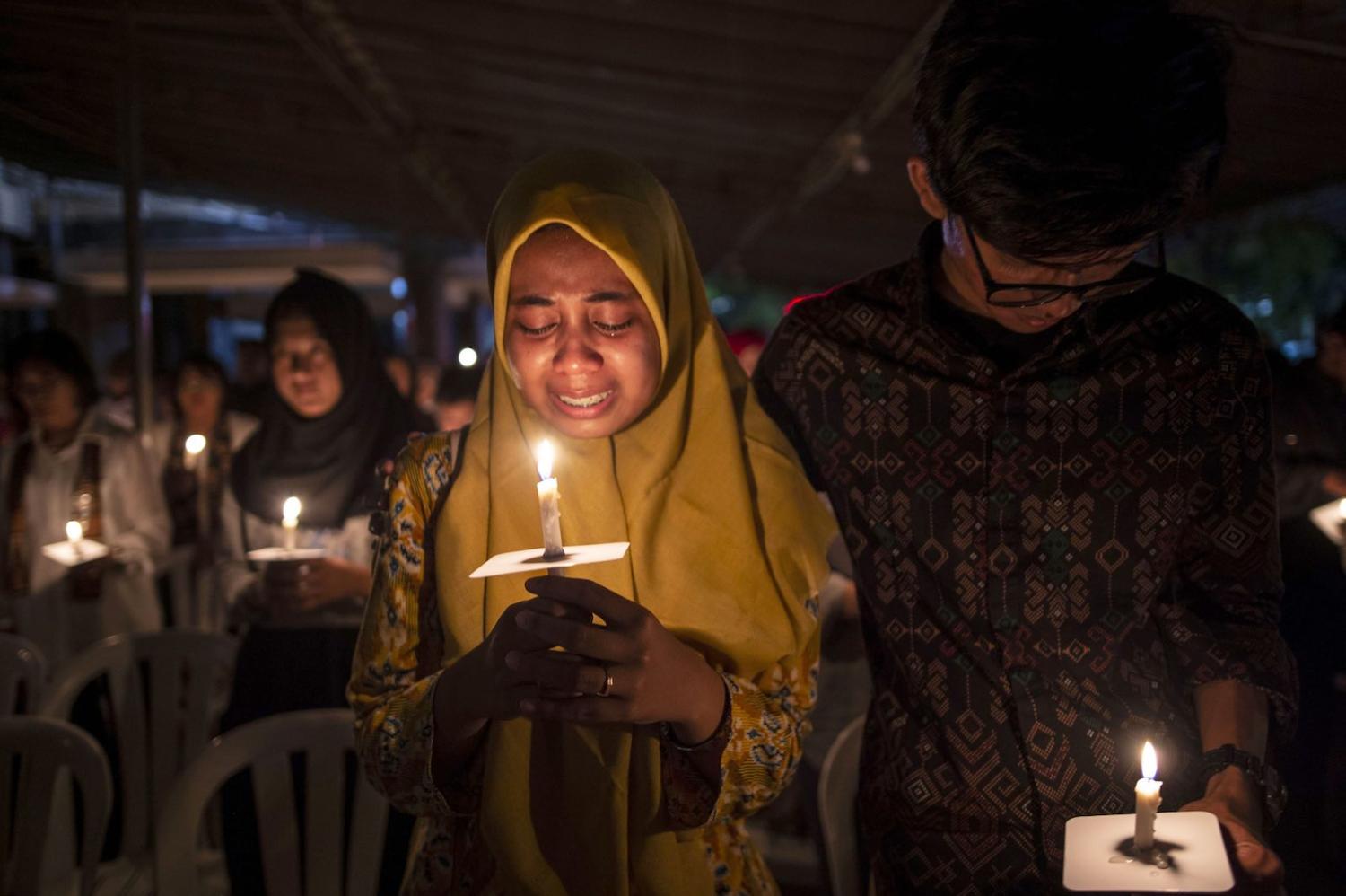 Tears during a candlelight vigil to remember the victims of the 2018 Surabaya suicide bombings (Photo: Juni Kriswanto via Getty)