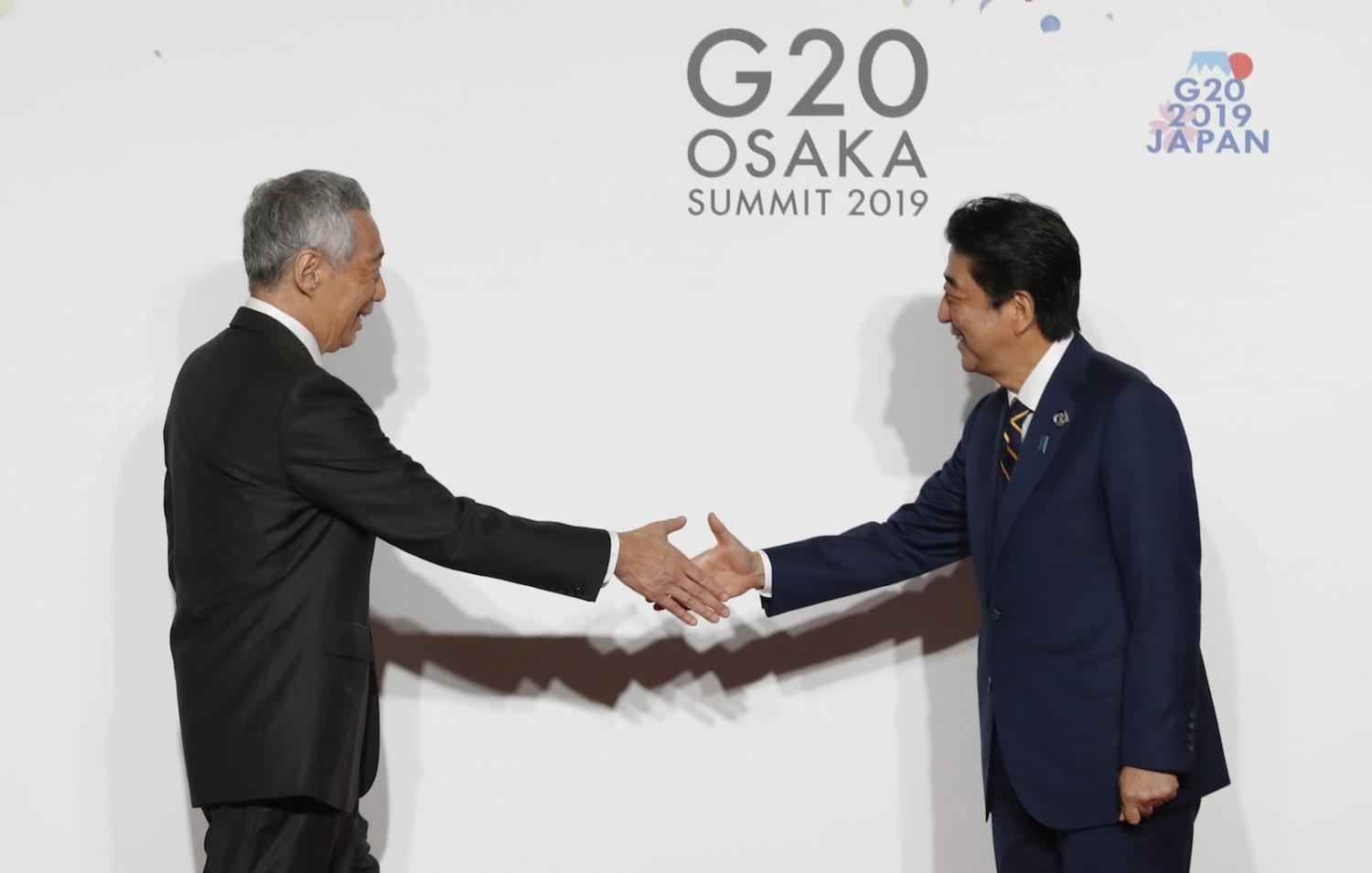 Singapore PM Lee Hsien Loong (L) is welcomed by Japanese PM Shinzo Abe at the G20 summit, June 2019 in Osaka, Japan. (Photo: Kim Kyung-Hoon via Getty)